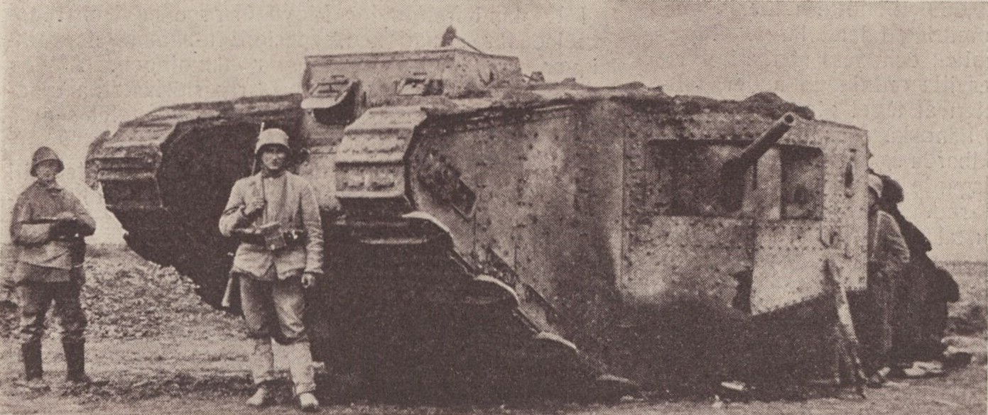 Svartvitt fotografi på tre tyska soldater vid en erövrad engelsk stridsvagn. 