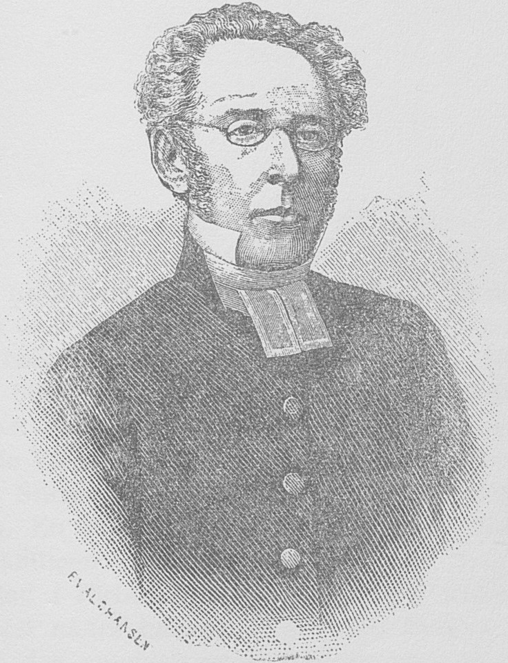 Porträtt av Anders Lindbäck i prästdräkt, örnnäsa, krulligt hår och runda glasögon.