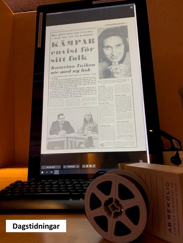 På en skärm syns en artikel om Katarina Taikon med rubriken "Kämpar envist för sitt folk", nedanför skärmen ligger en mikrofilmsrulle.