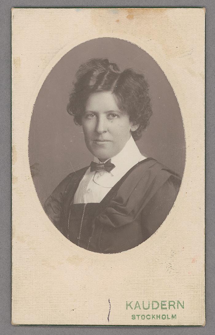 Fotografi av en ung kvinna med kort schinglat mörkt hår avbildad i halvfigur.