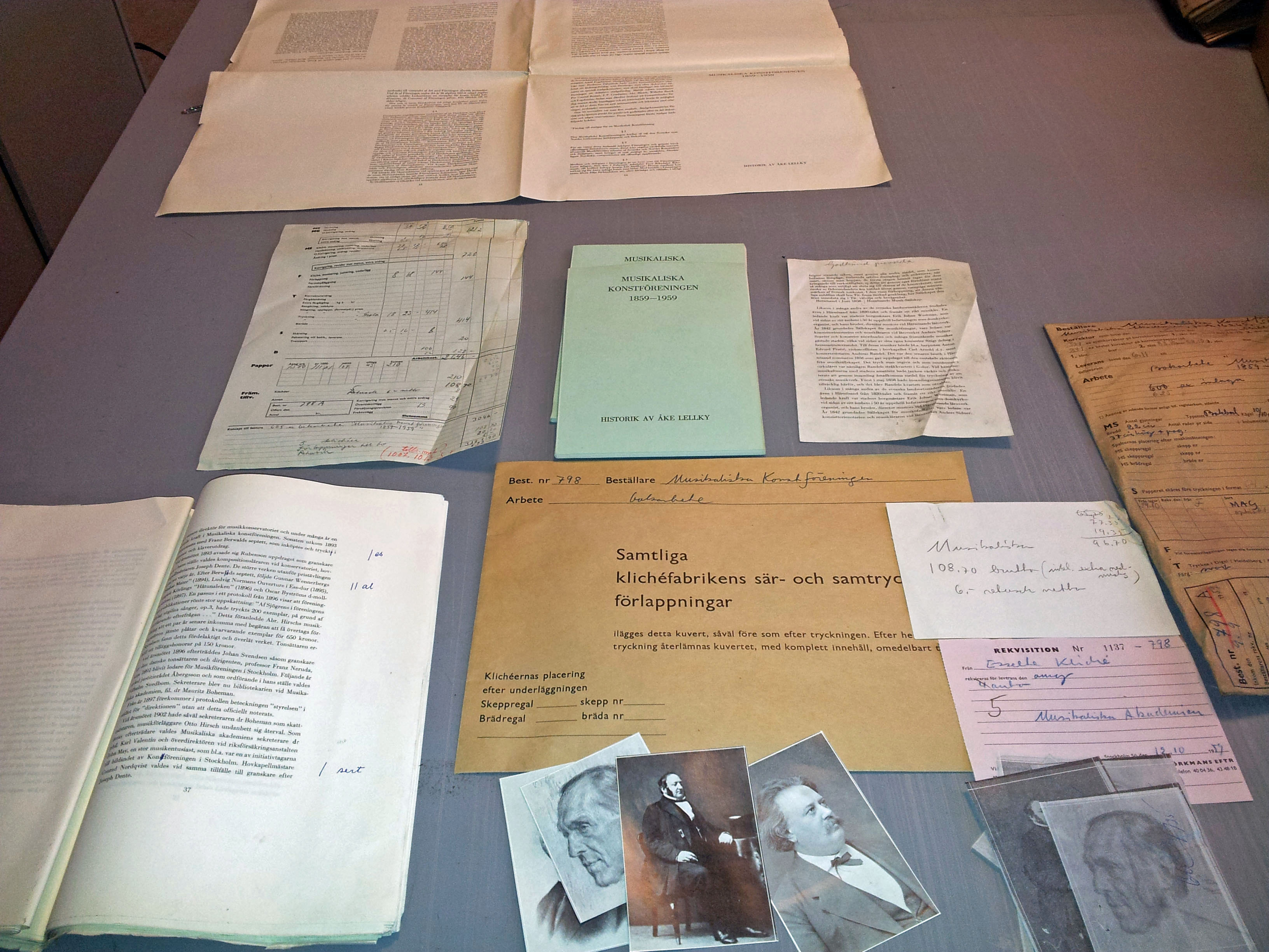 Exempel på innehåll i samlingen: textmaterial, korr, bilder, tidrapporter, anteckningar ligger utspridda på ett bord.