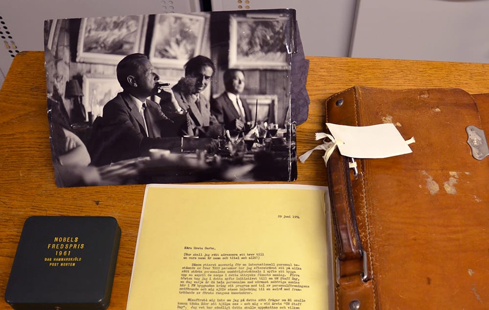 Bild på delar av Dag Hammarskjölds samling på KB: ett foto, ett bre, en läderportfölj och en ask till Nobels fredspris.