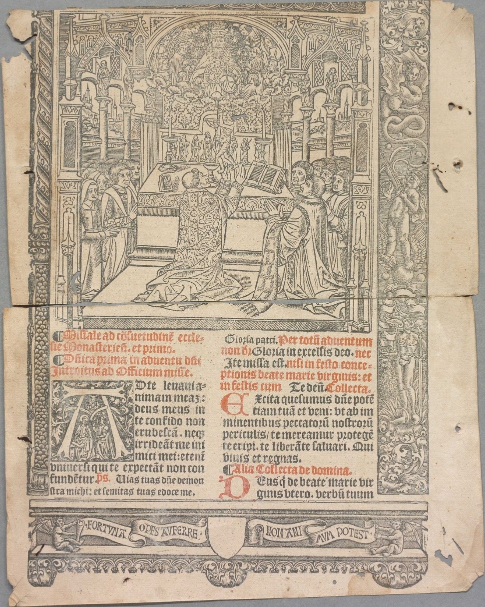 Färgfoto av ett slitet tryckt blad med tysk text i svart och rött omgiven av en dekorerad bård. Överst på bladet syns en bild av munkar som knäböjer i en kyrka.