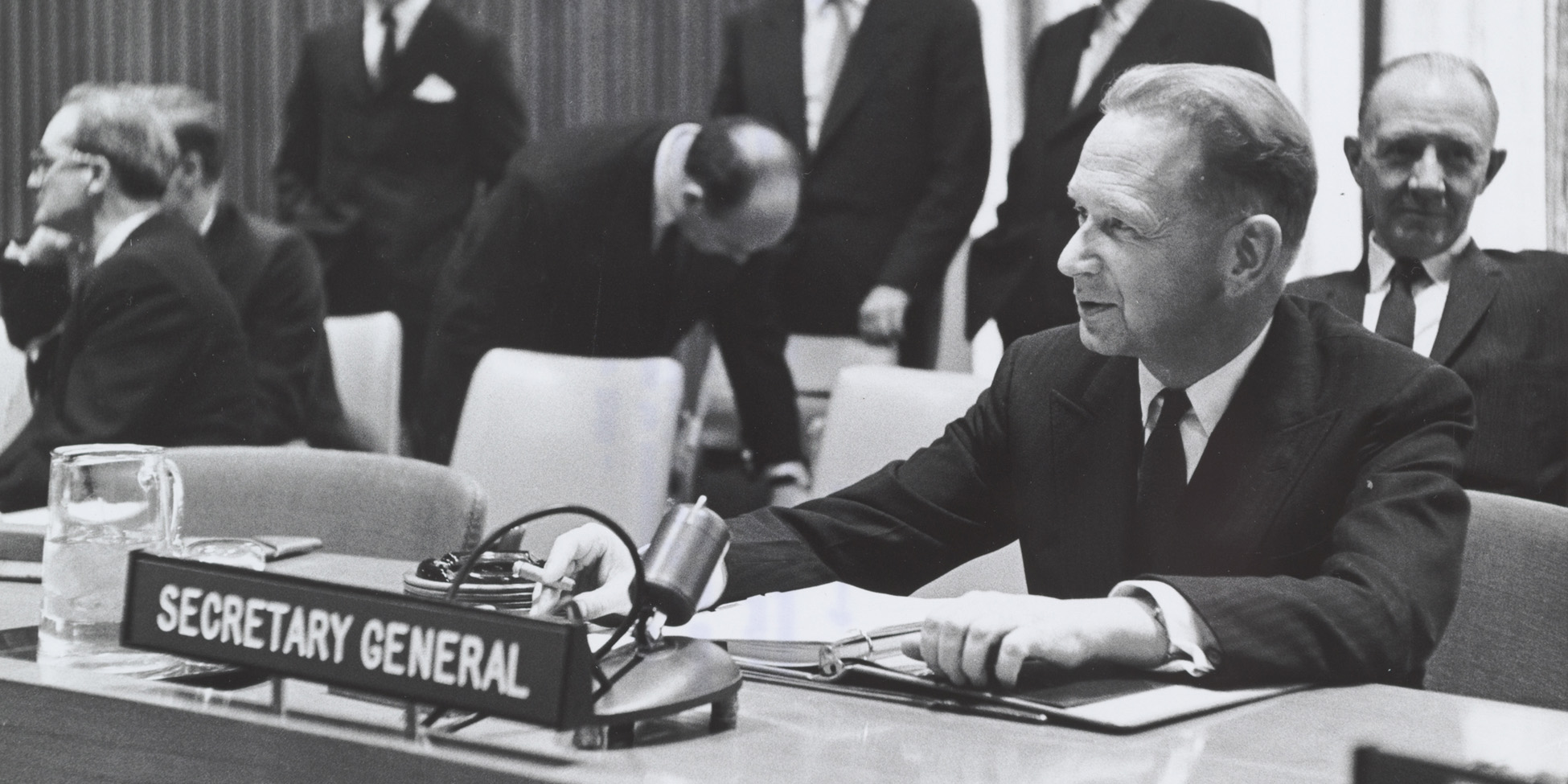 Svartvitt foto av Dag hammarskjöld vid ordförandebordet i FN.