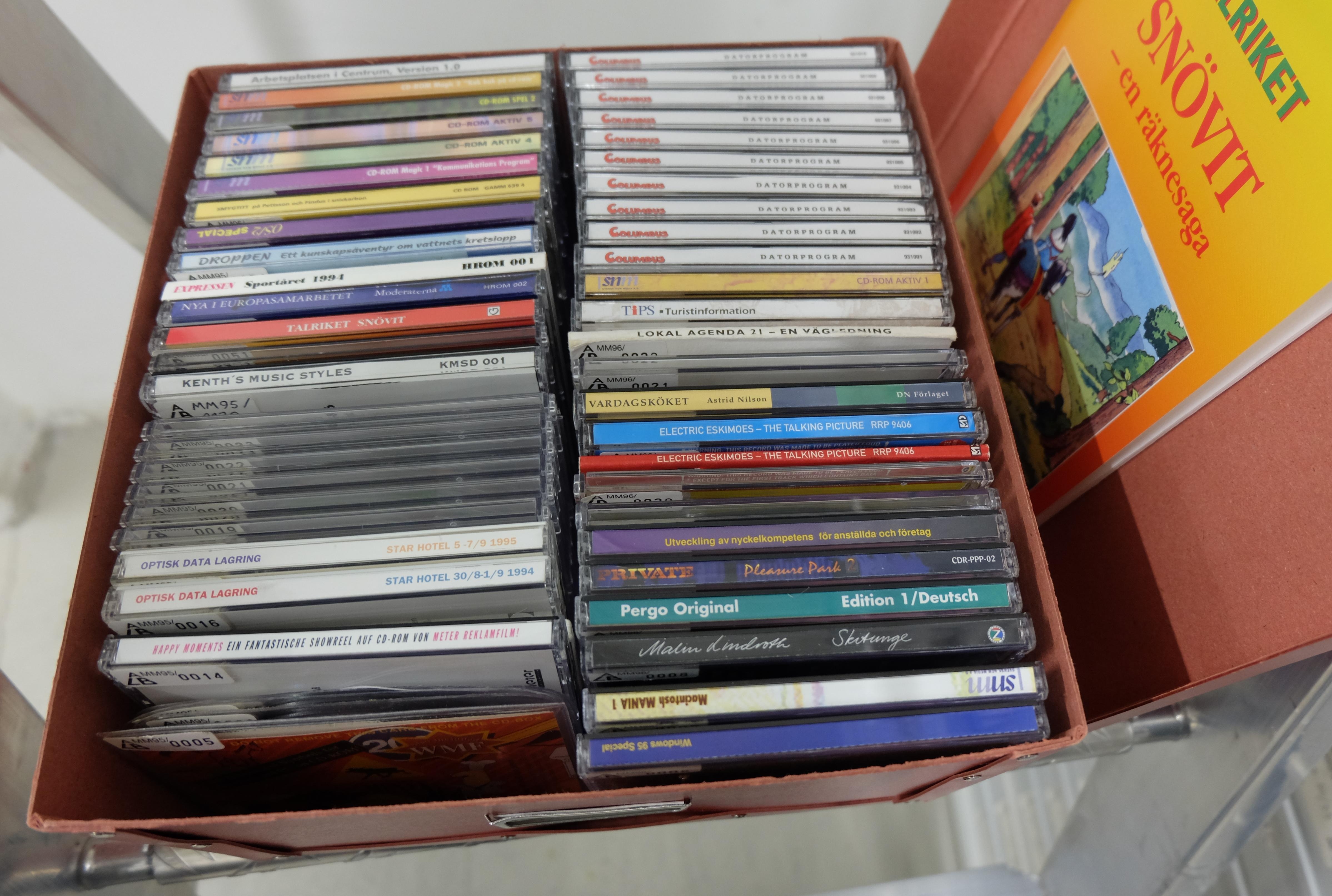 CD:s of different colors in a box.