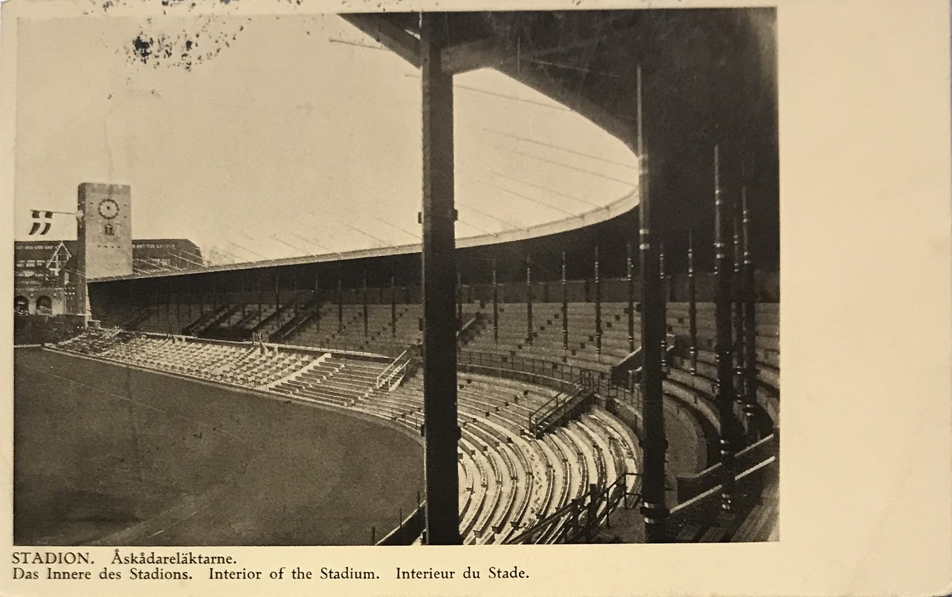 Vykort med ett svartvit fotografi av en tom åskådarläktare på Stockholms stadion.