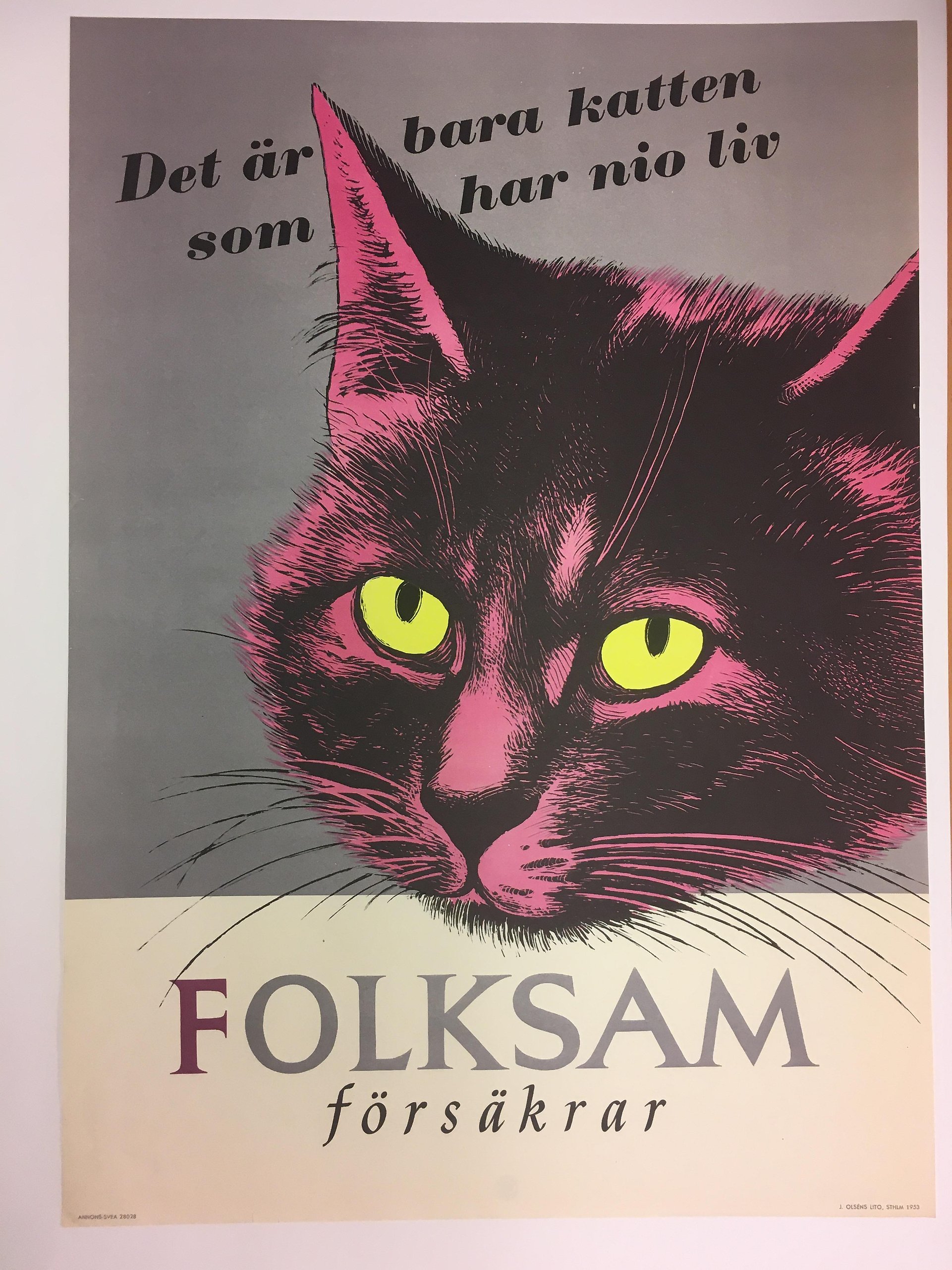 Affisch med ett tecknat rosa-svart katthuvud med gula ögon och texten "Det är bara katten som har nio liv. Folksam försäkrar". 