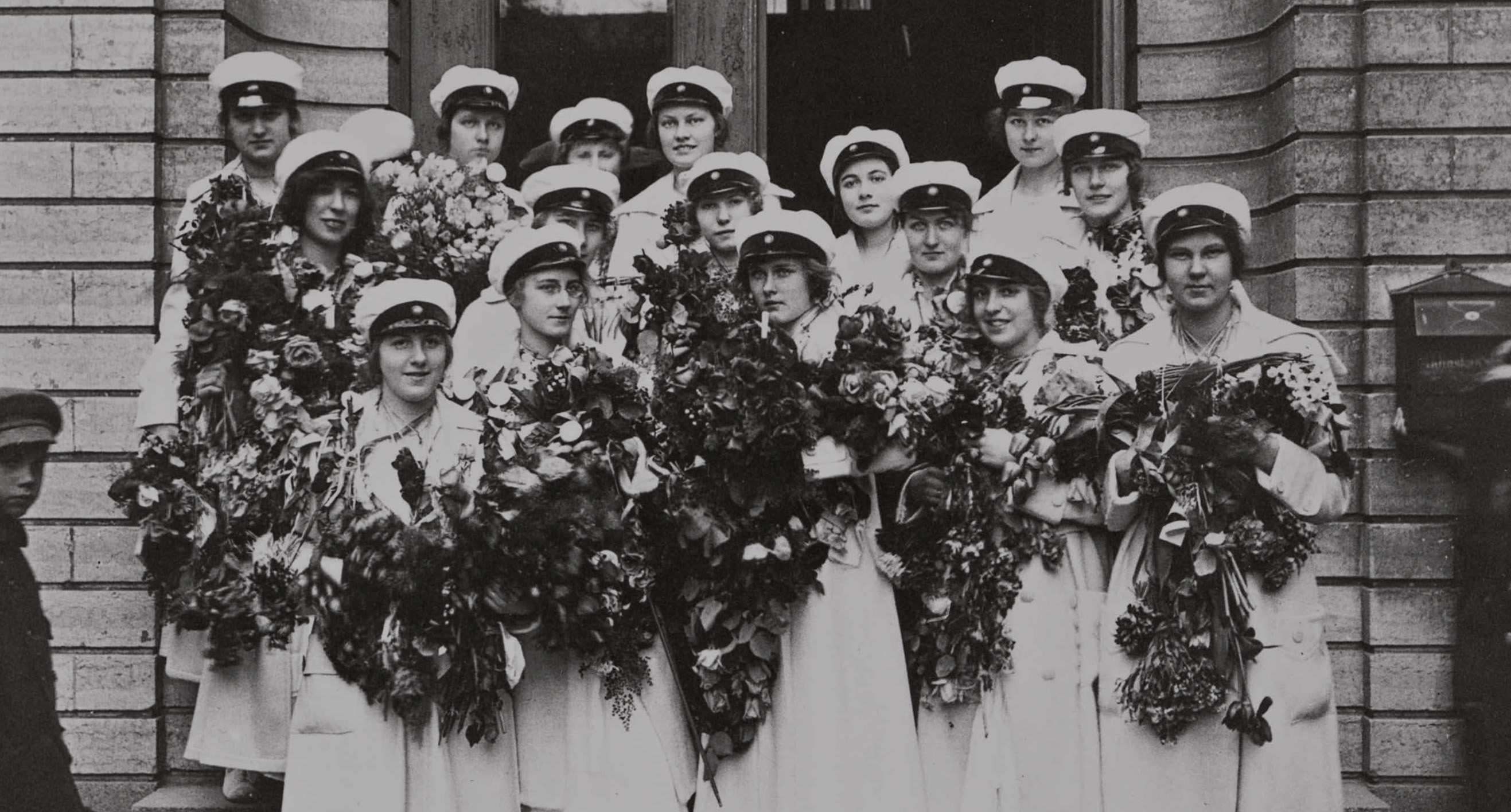 Foto från tidigt 1900-tal av en grupp kvinnliga studenter på en trappa.