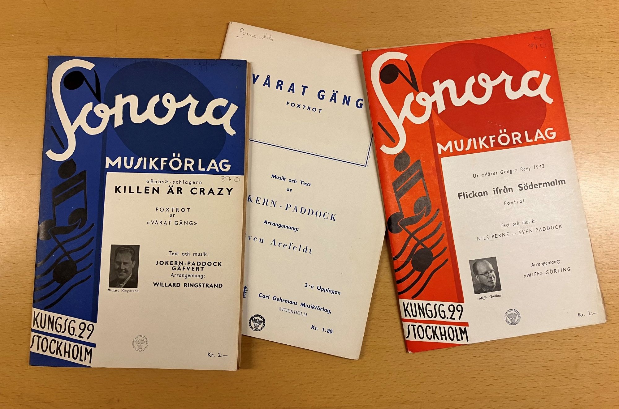 Färgfoto av omslagen till tre musiktryck med blå och röda detaljer