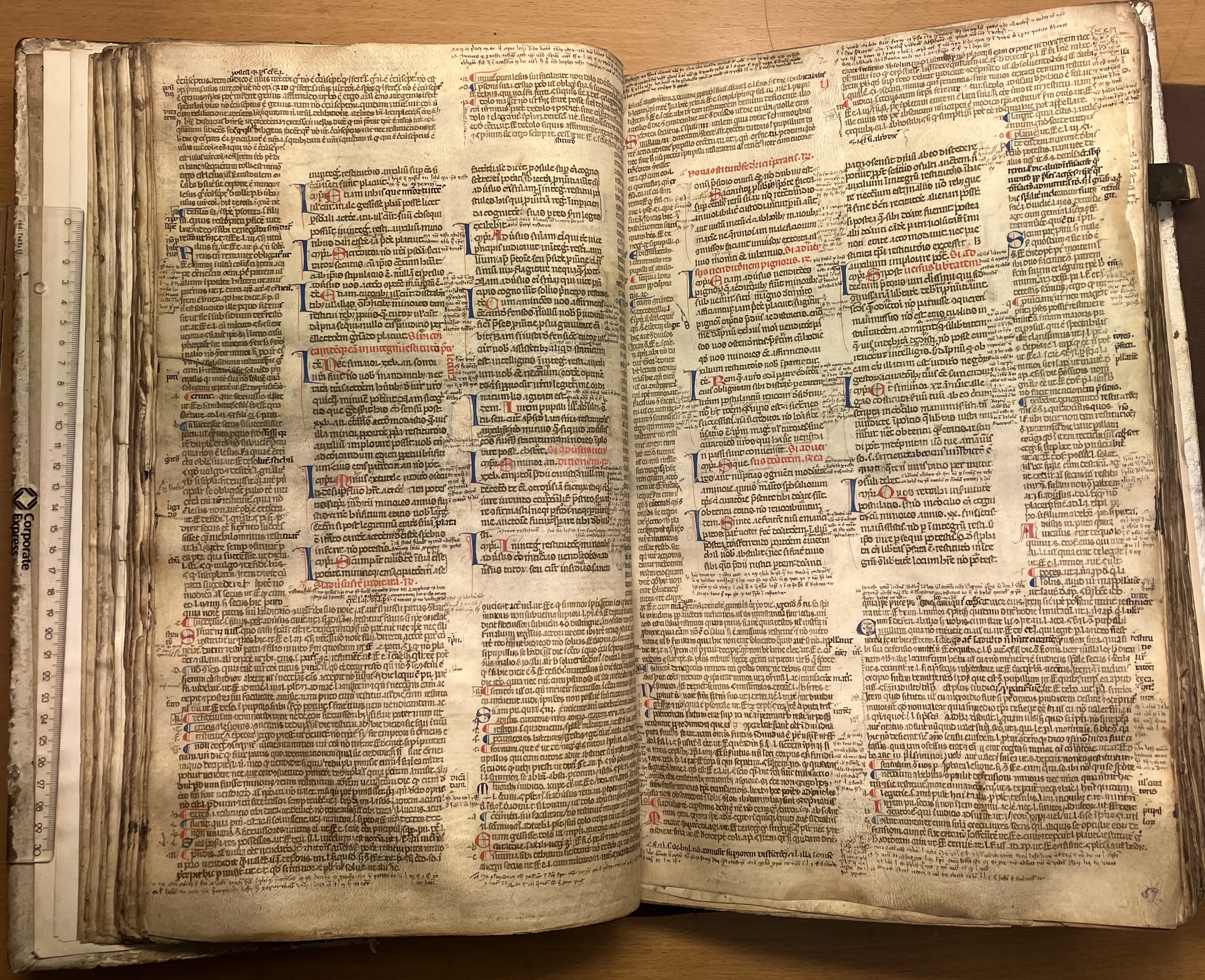 Färgfoto av uppslagen handskrift med tätt skriven text. Till vänster i bild syns en linjal som är lite kortare än höjden på sidan.