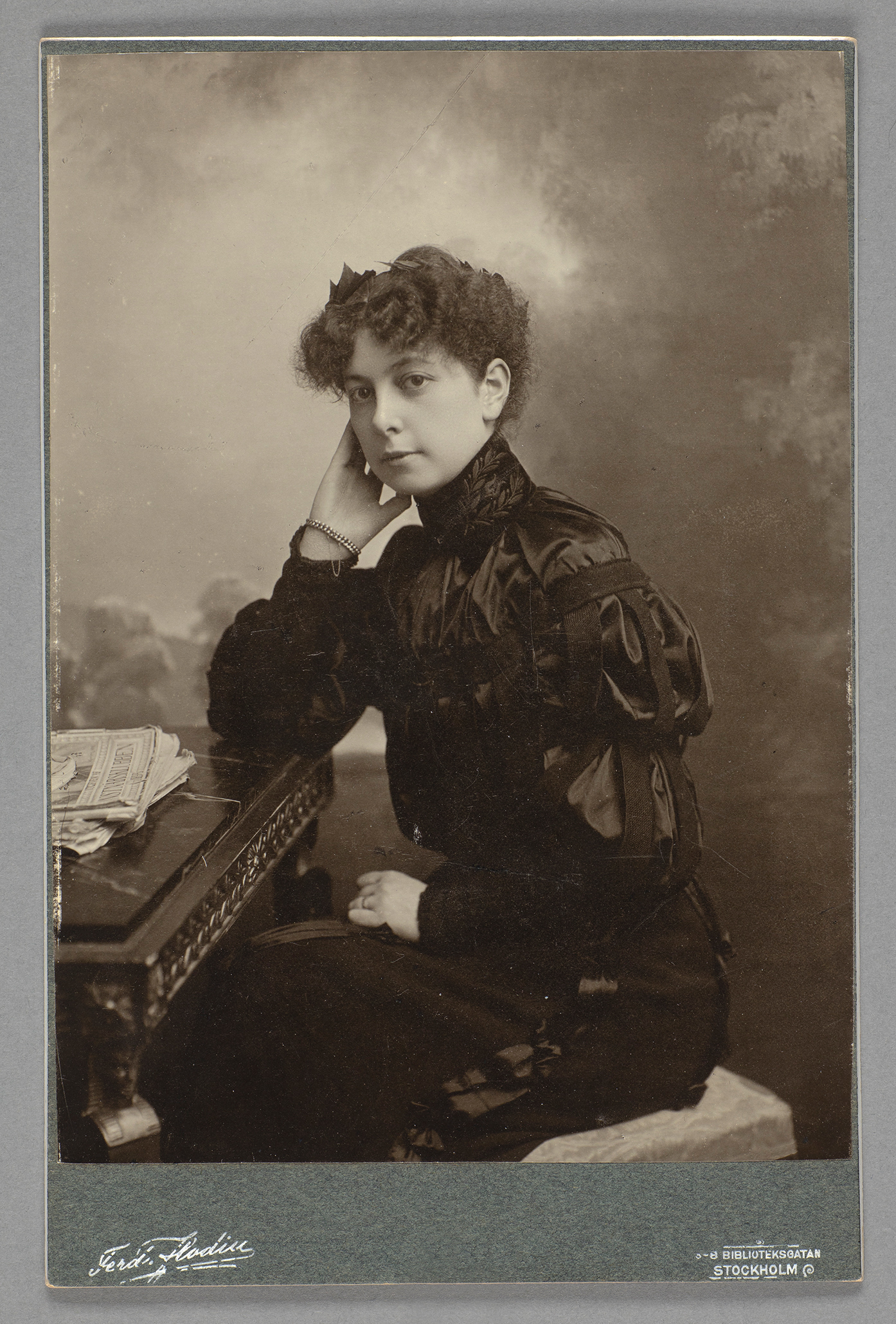 Black and white photograph of woman in black side dress.
