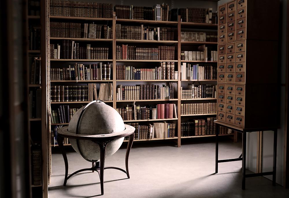 Interiör från Roggebiblioteket med bokhyllor, jordglob och kortkatalog