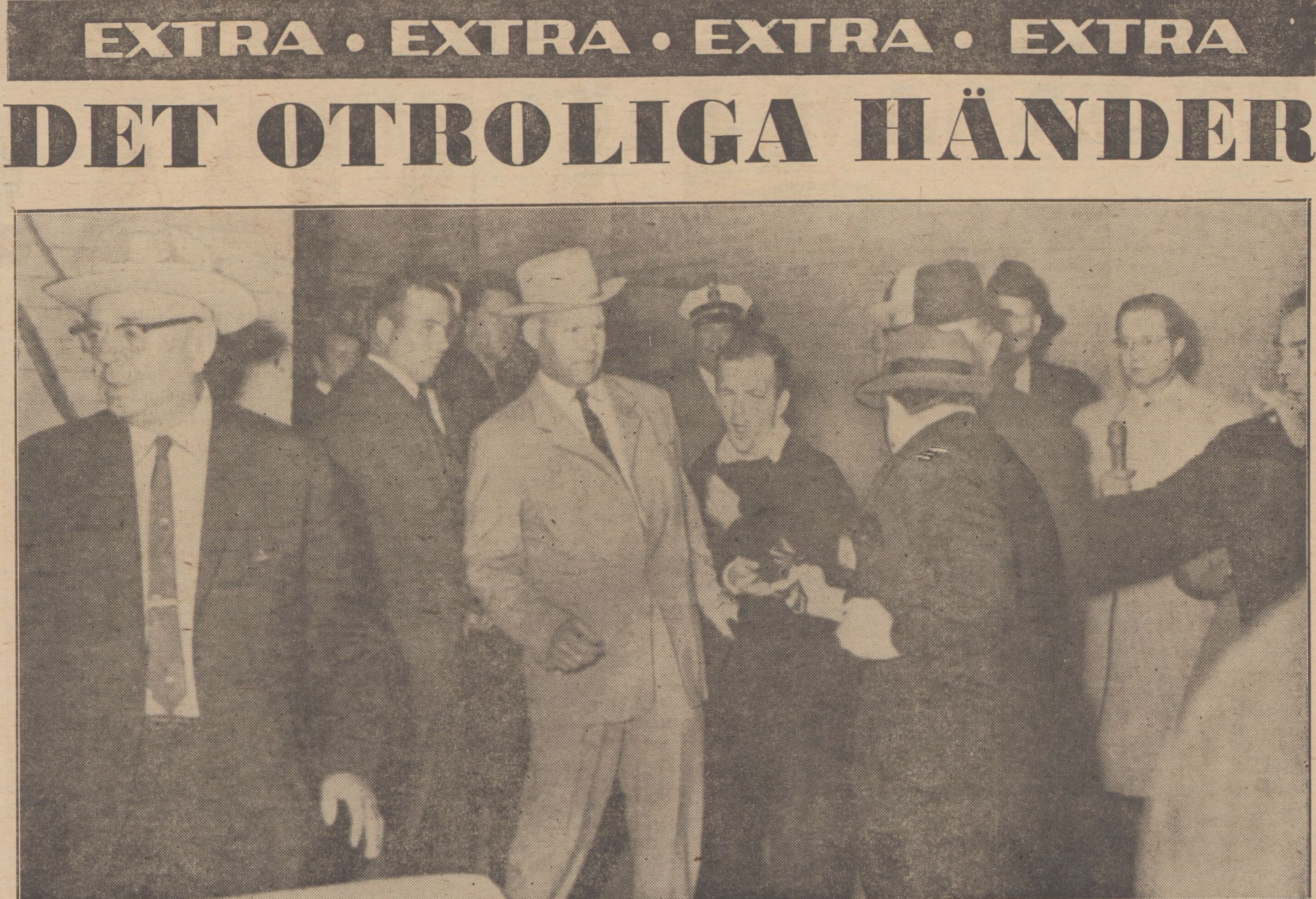 Tidningsklipp med fotografi där en man i hatt med ryggen mot kameran skjuter en man klädd i svart. Människor omkring hinner inte reagera.