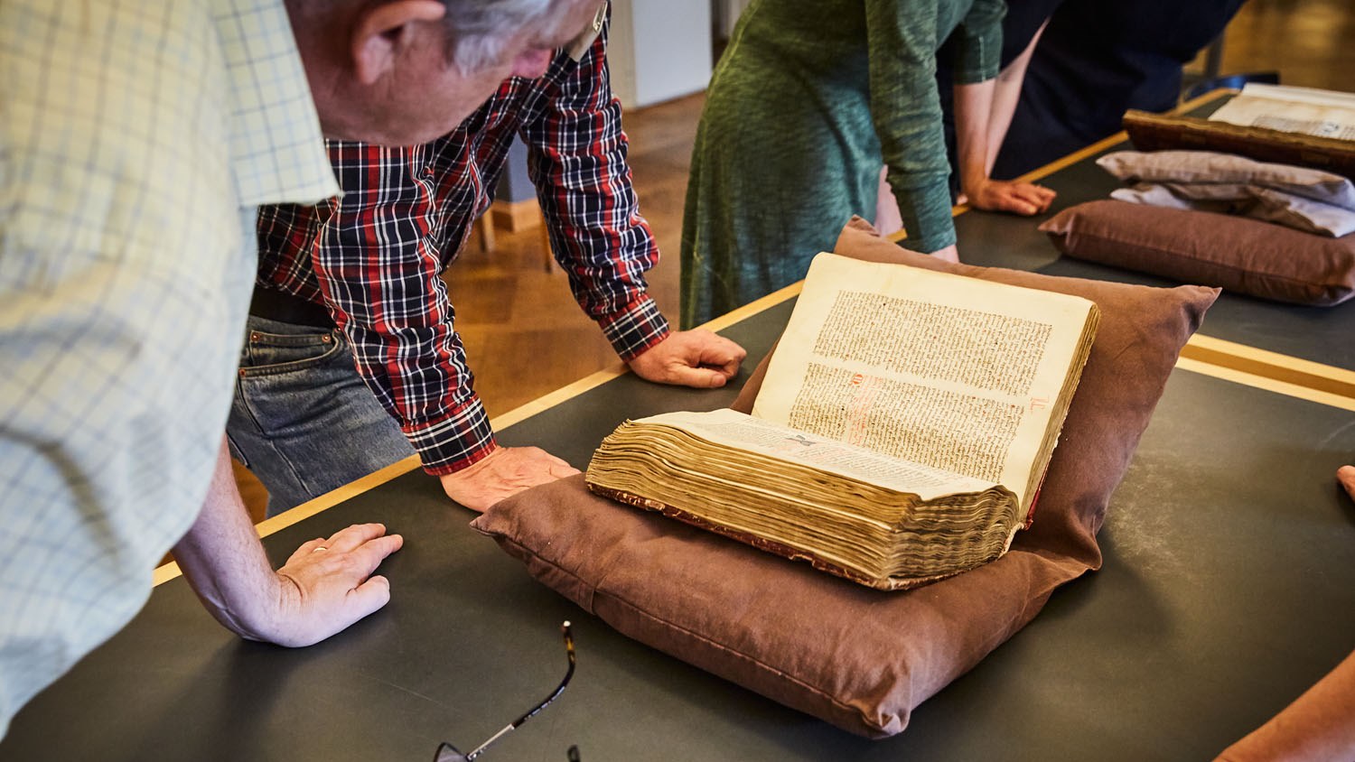 A group of people studying an old manuscript.