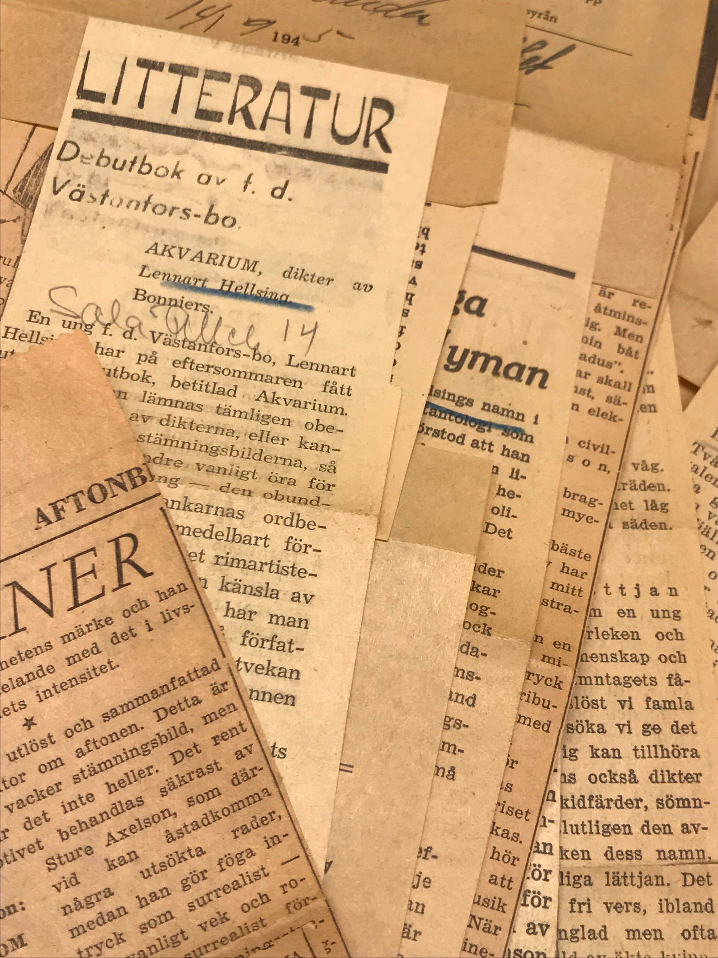 Bilden visar en bunt med gulnade pressklipp, överst ligger en recension av Hellsings debutbok Akvarium.