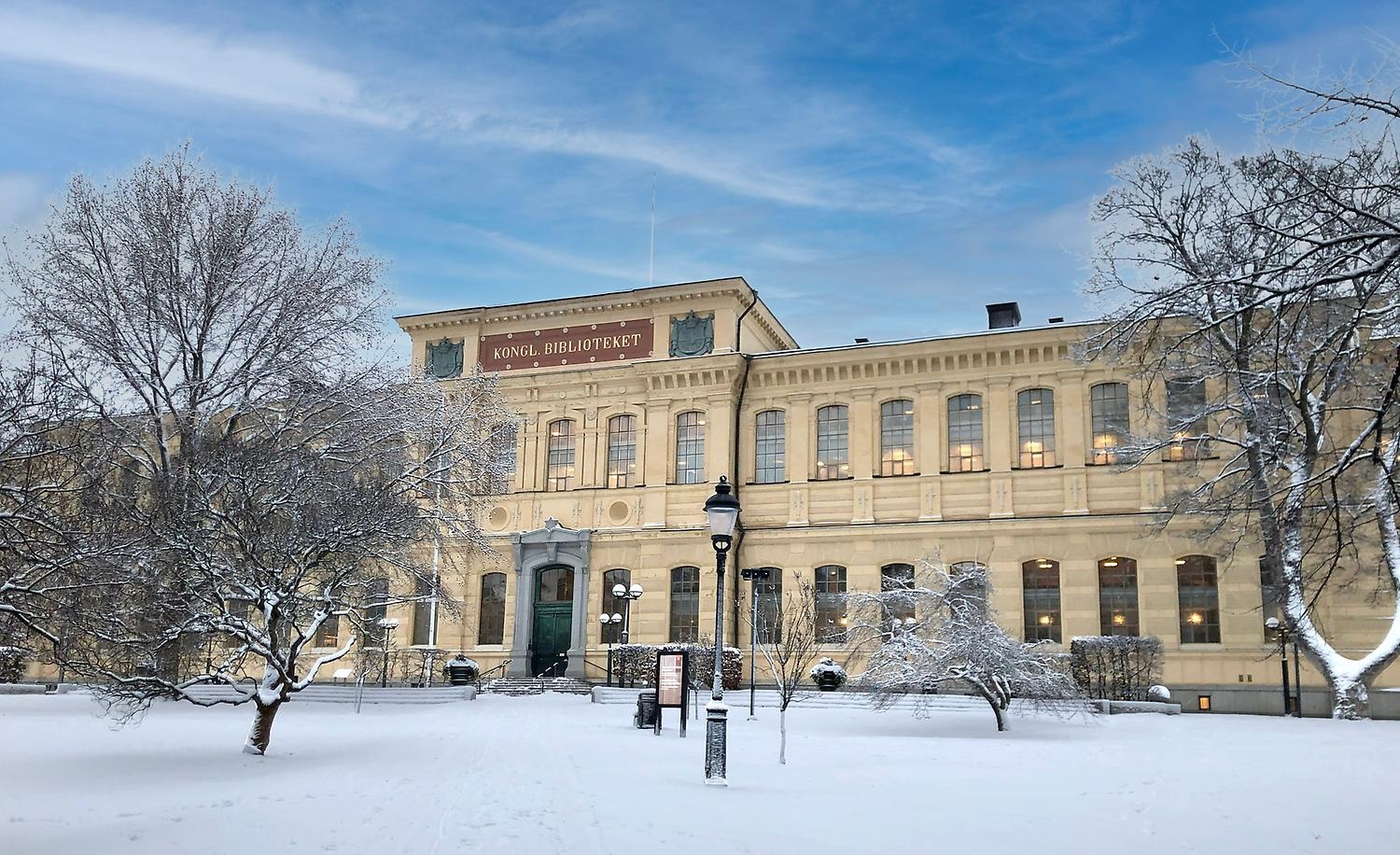 Stor äldre biblioteksbyggnad i snölandskap.