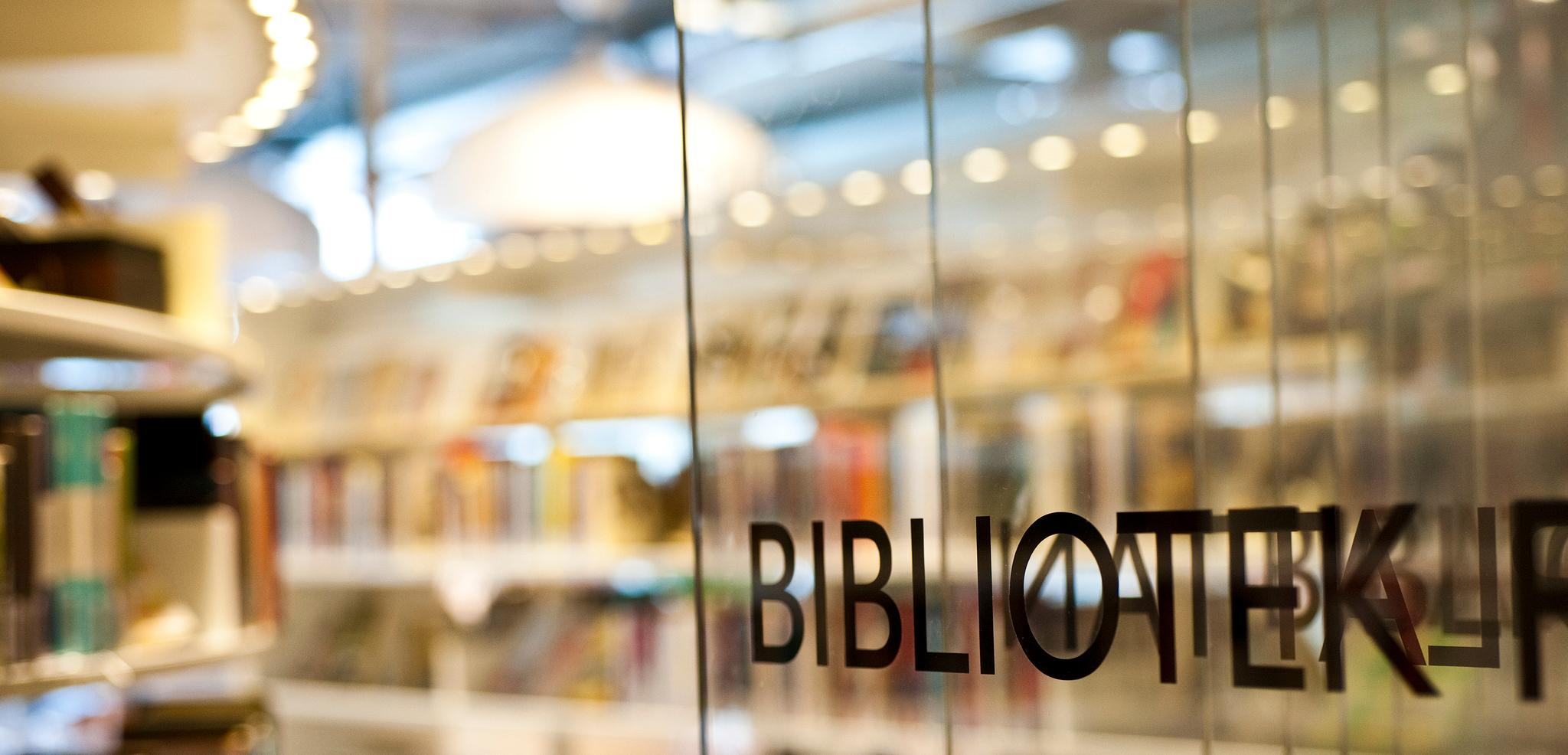 Glasdörr som leder in till bibliotek.