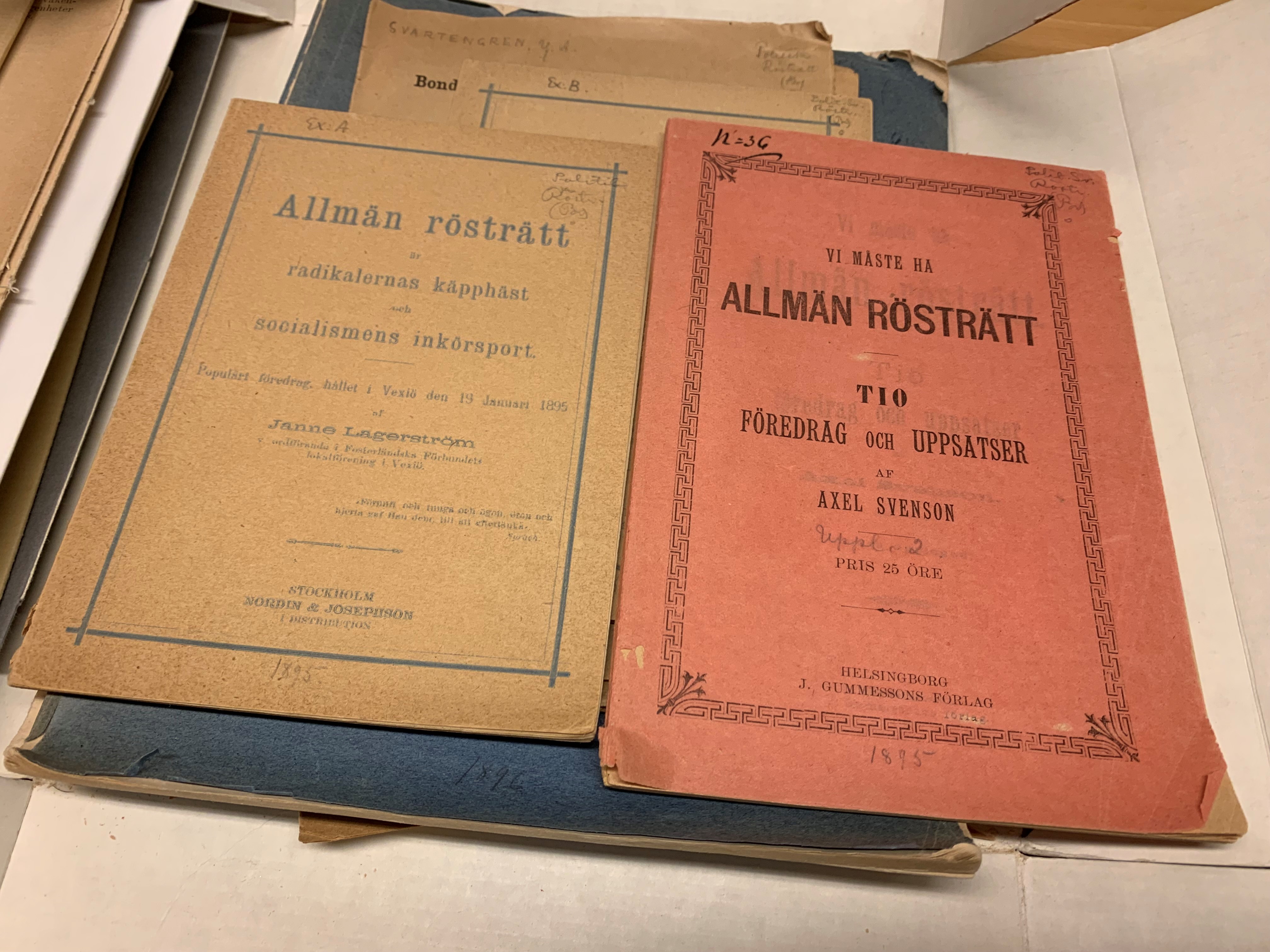 Två broschyrer med inramade titlar på omslagen, den ena gul och den andra röd.