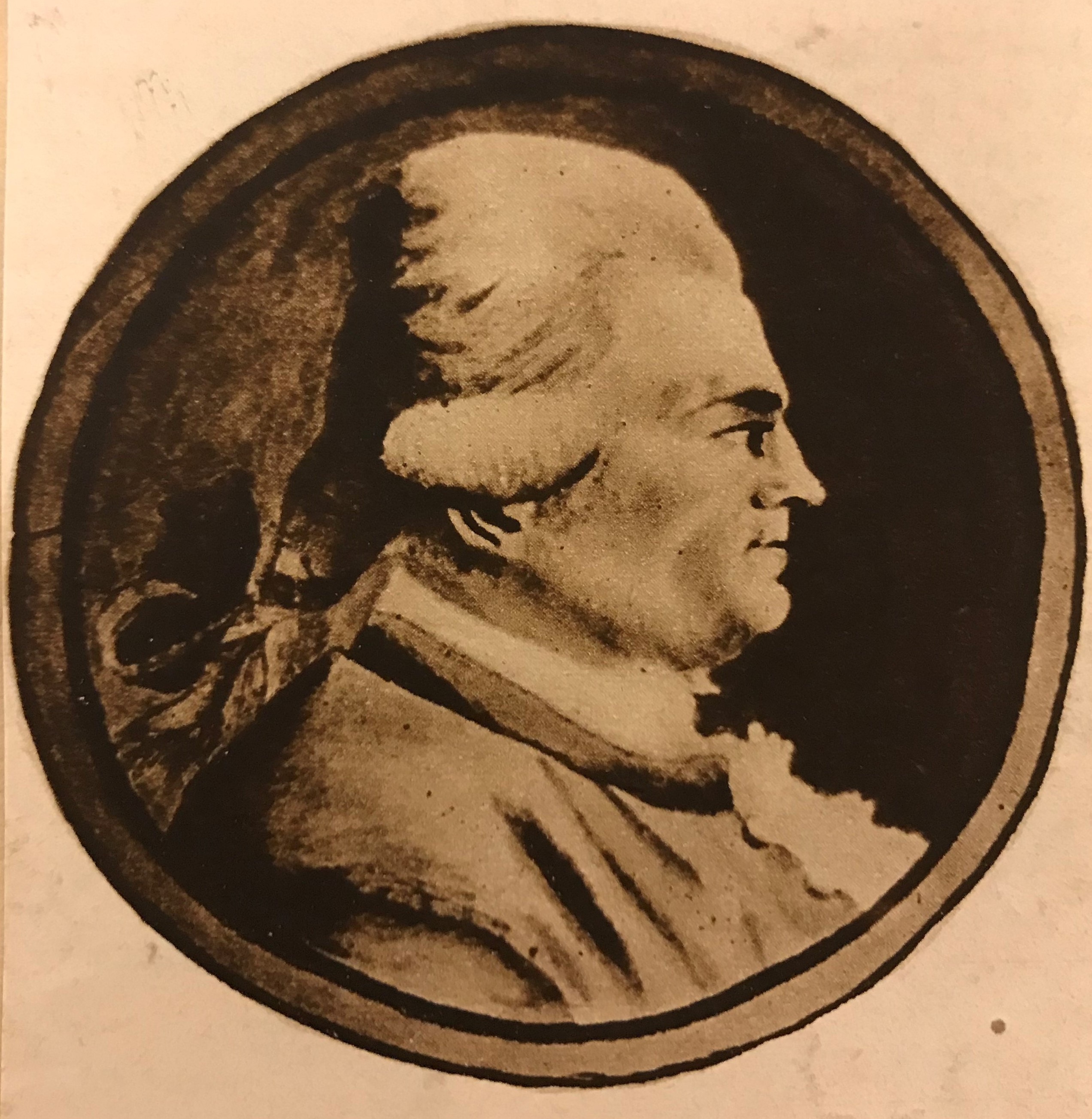 Bröstbild i profil av en man med peruk innanför en rund ram