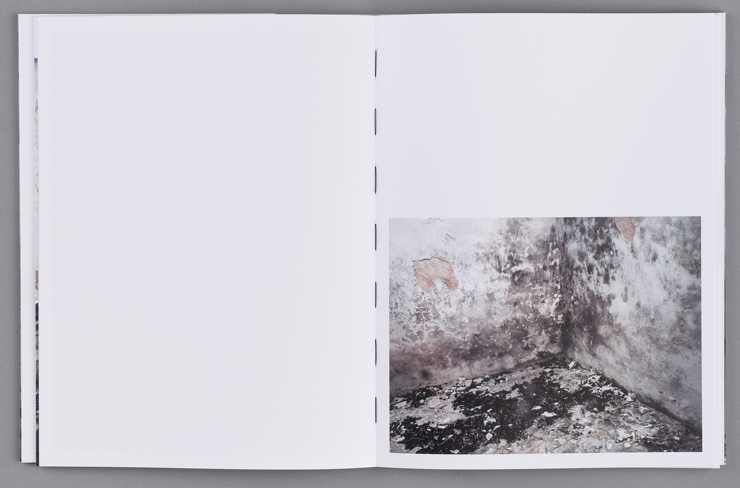 Ett uppslag i en bok med bild av förstörelse efter brand och en svart tråd mellan sidorna.