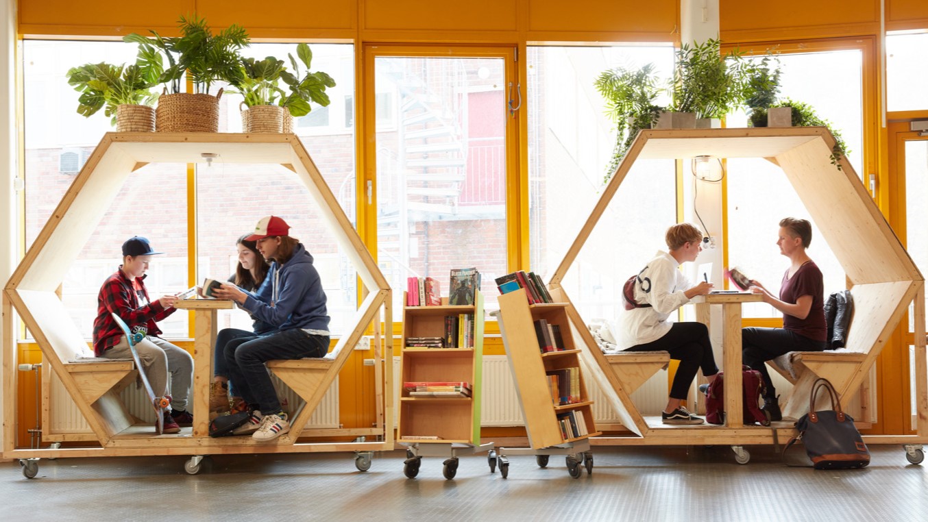 Personer sitter i hubbar i bibliotek. 