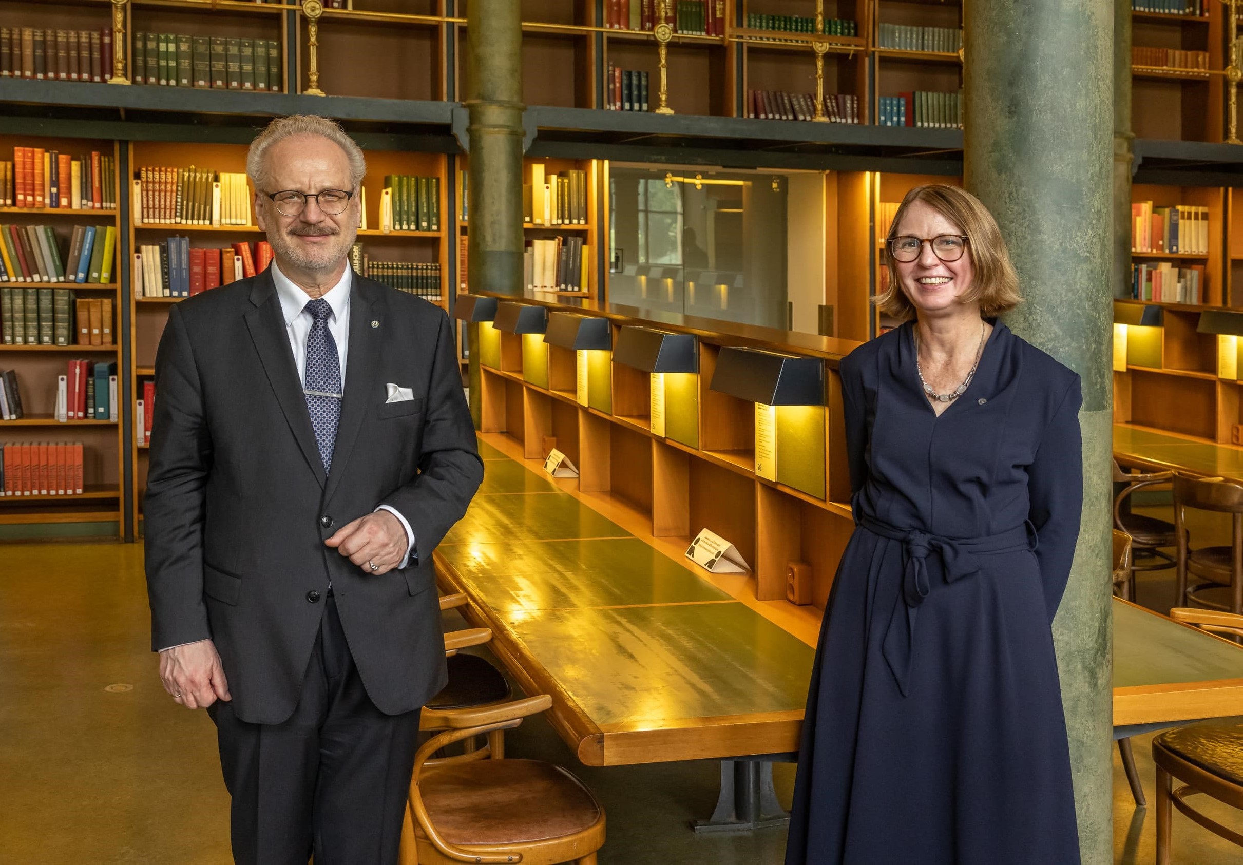 Lettlands president och riksbibliotekarie Karin Grönwall i en bibliotekssal med bokhyllor och arbetsplatser.
