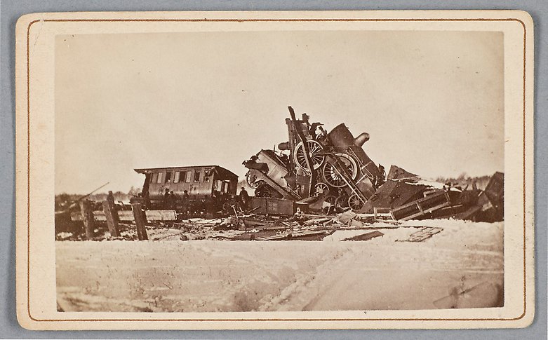 Svartvitt fotografi av ett tåg som ser ut att ha krockat och gått sönder.