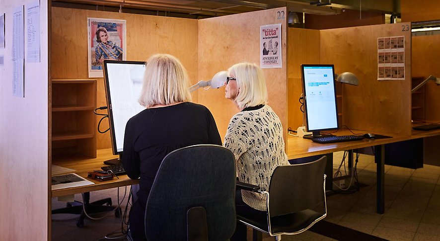 Två kvinnor sitter och tittar på en datorskärm.