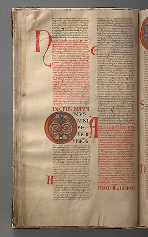 A book page with text and the initial o with colorful ornamentation.