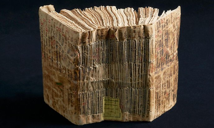 Ryggen på en gammal handskrift, bunden med smala trådar.