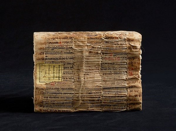 Ryggen på en gammal handskrift, bunden med smala trådar.