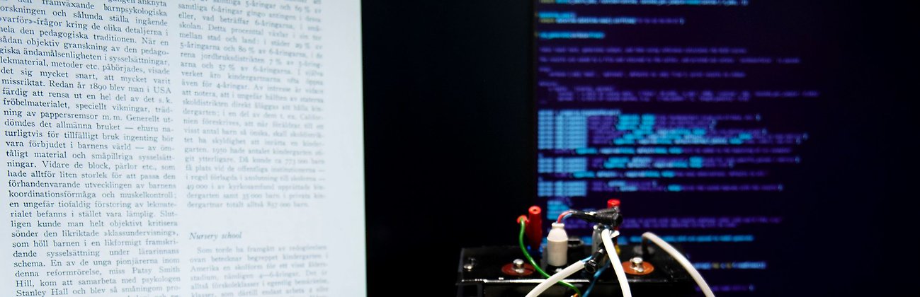 En skärm med text ur en bok bredvid en skärm med programmeringskod.