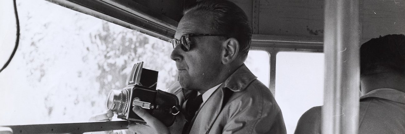 Svartvitt fotografi av Dag Hammarskjöld med kamera.