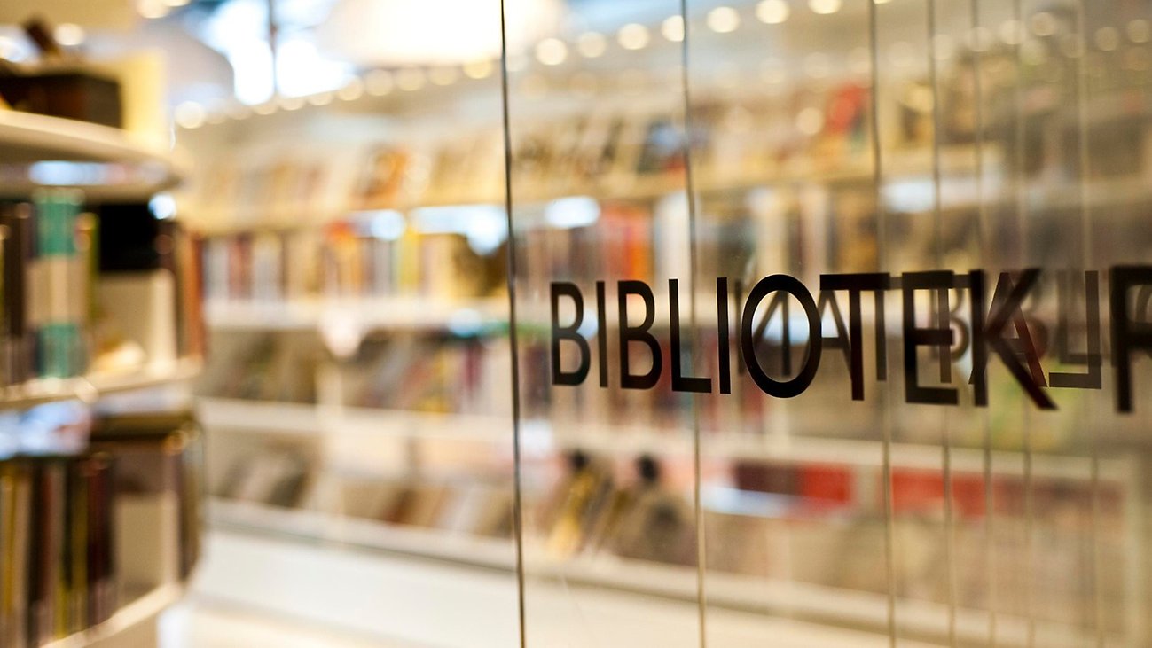 En glasvägg i ett bibliotek med texten "Bibliotek".