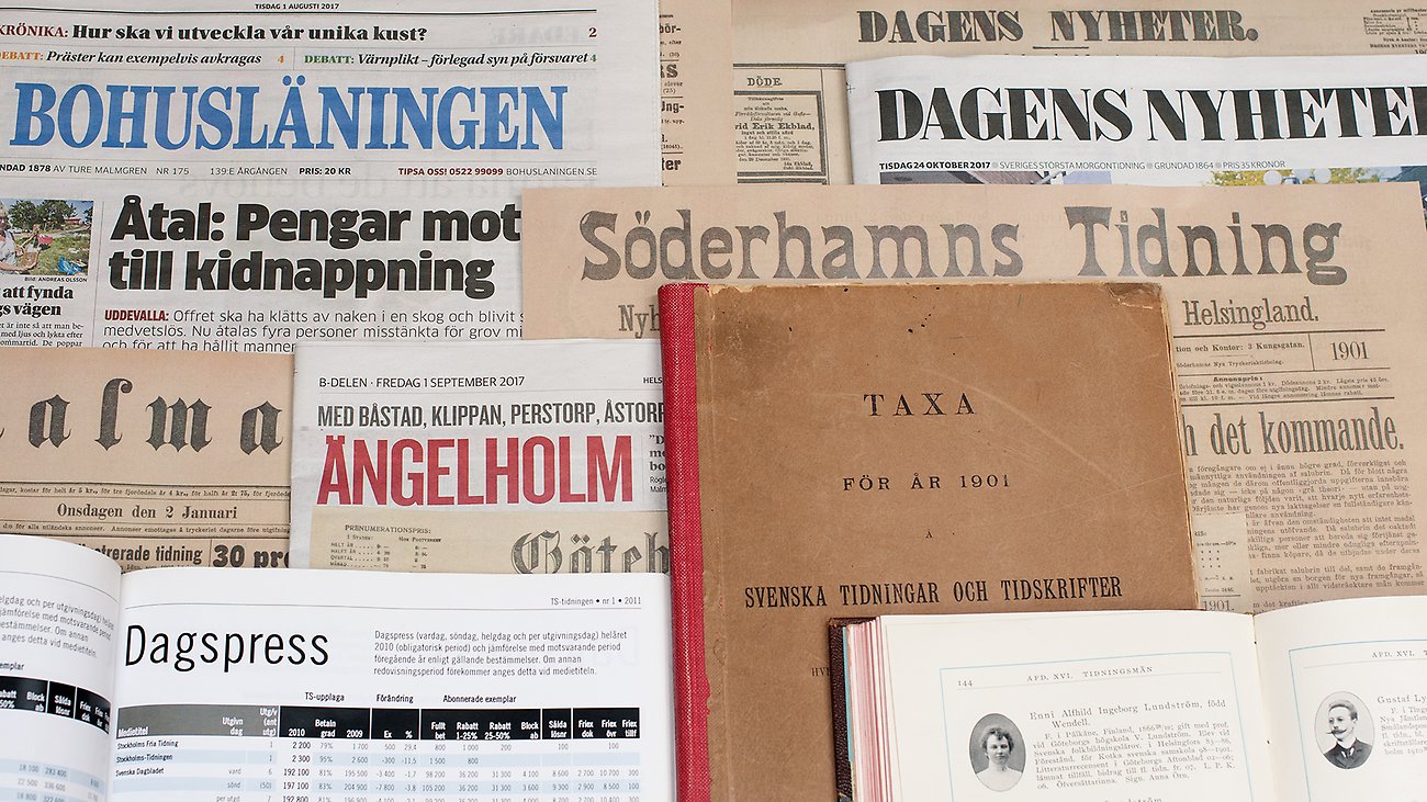 A number of different newspapers stacked on top of each other on a table.