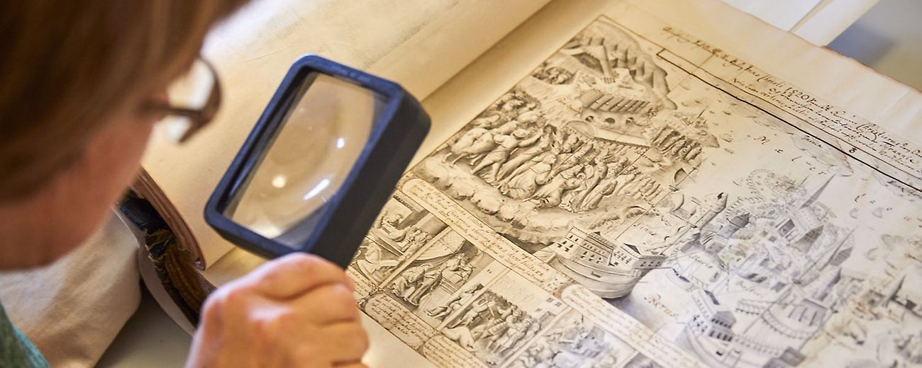 Person som granskar en handritad bild med förstoringsglas.