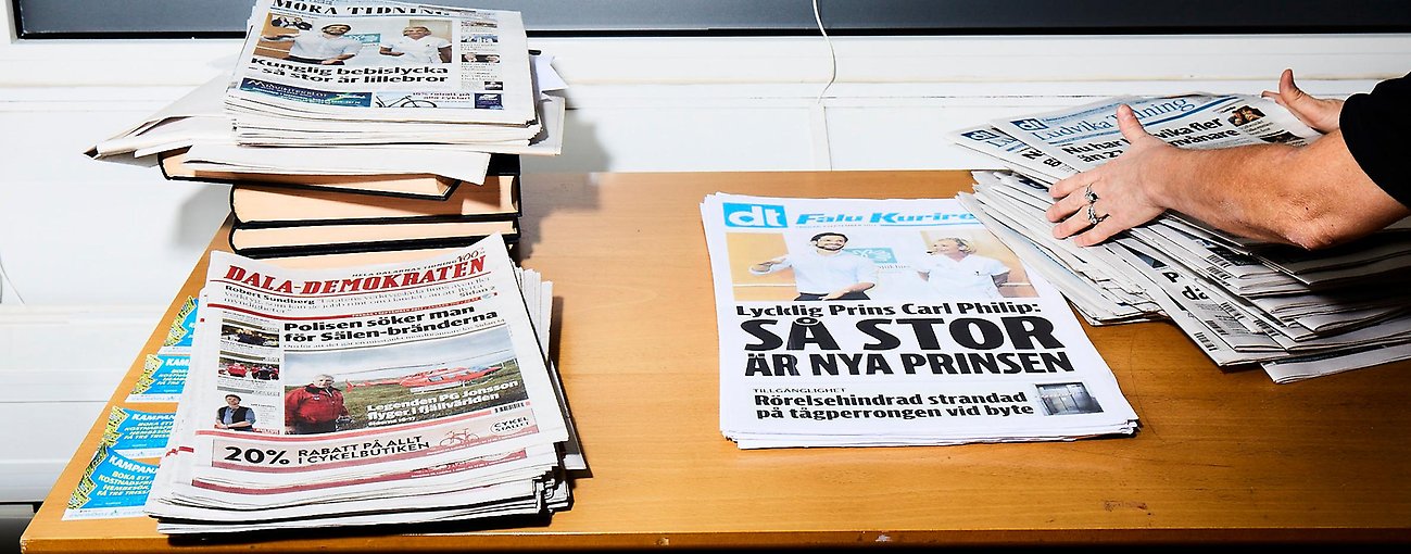 Tidningshögar på bord. 