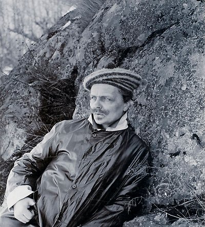 Black and white photograph of a man wearing a coat and hat.