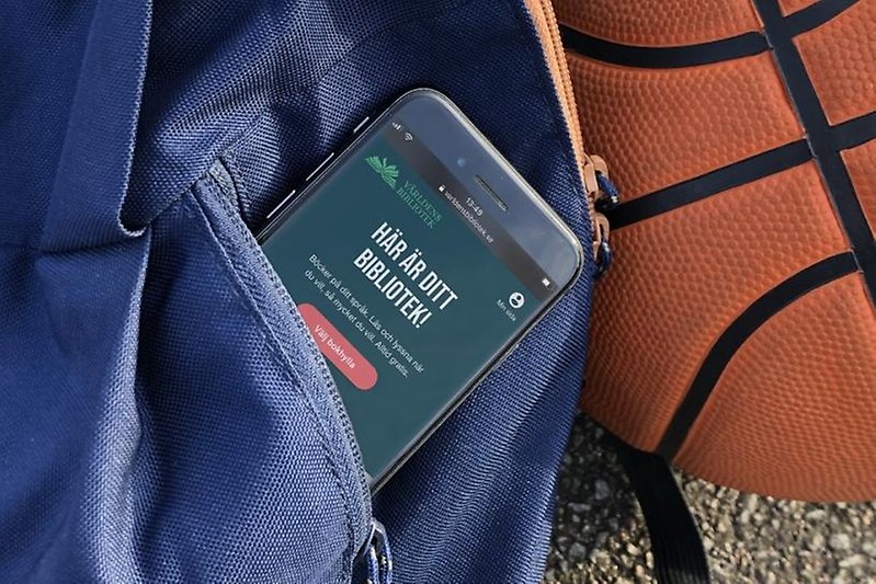 Person håller upp en mobil med Världens bibliotek.