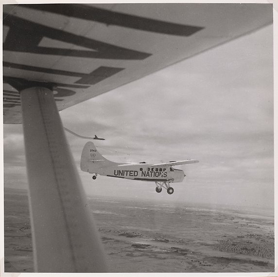 Ett flygplan med United Nations skrivet på sidan, fotat från luften.