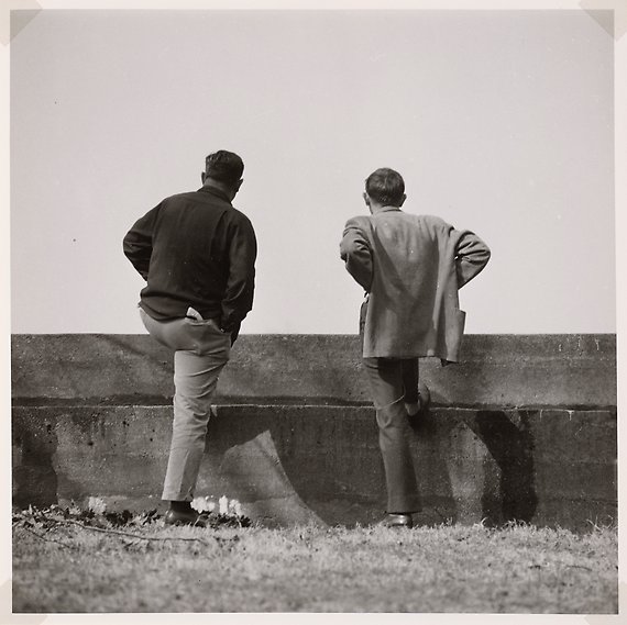 Två personer med ryggar vända mot kameran som tittar ut mot horisonten